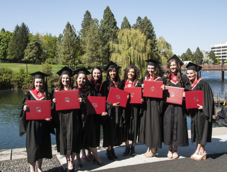 WSU Spokane students show off their diplomas after the 2015 commencement ceremony.